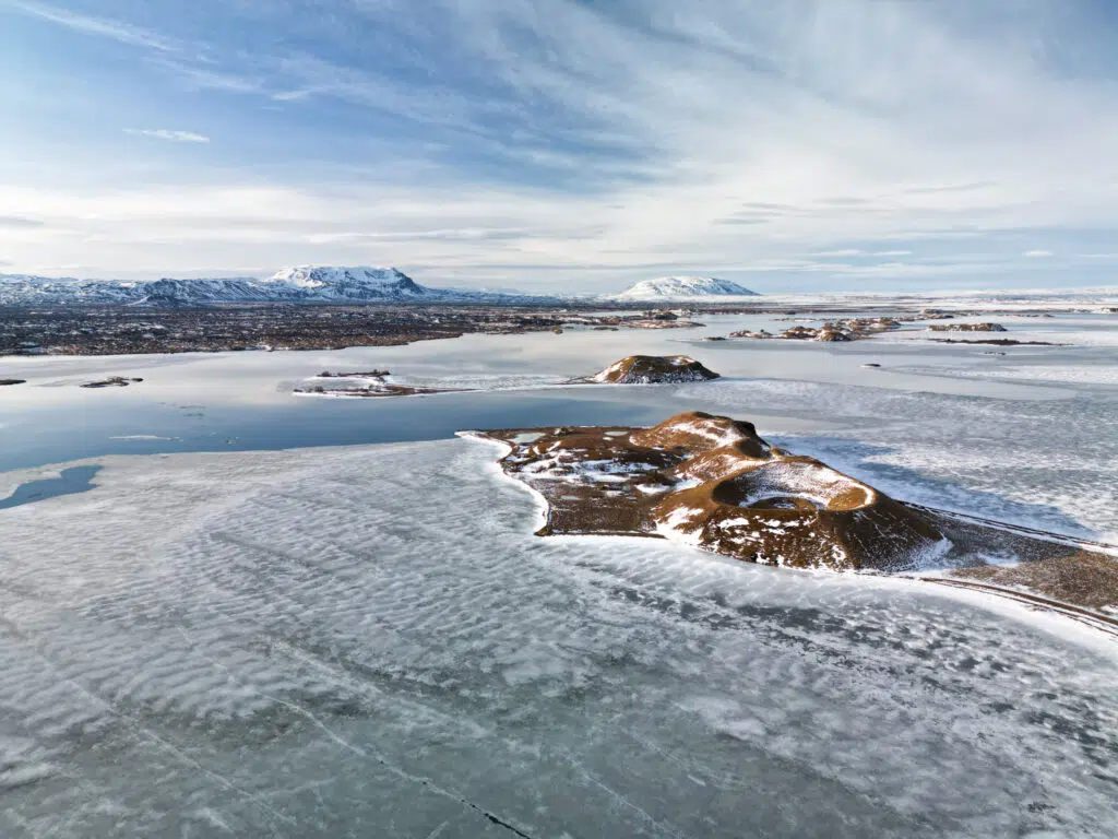 A scenic view of snowy mountain peaks and icy waters in Norway.